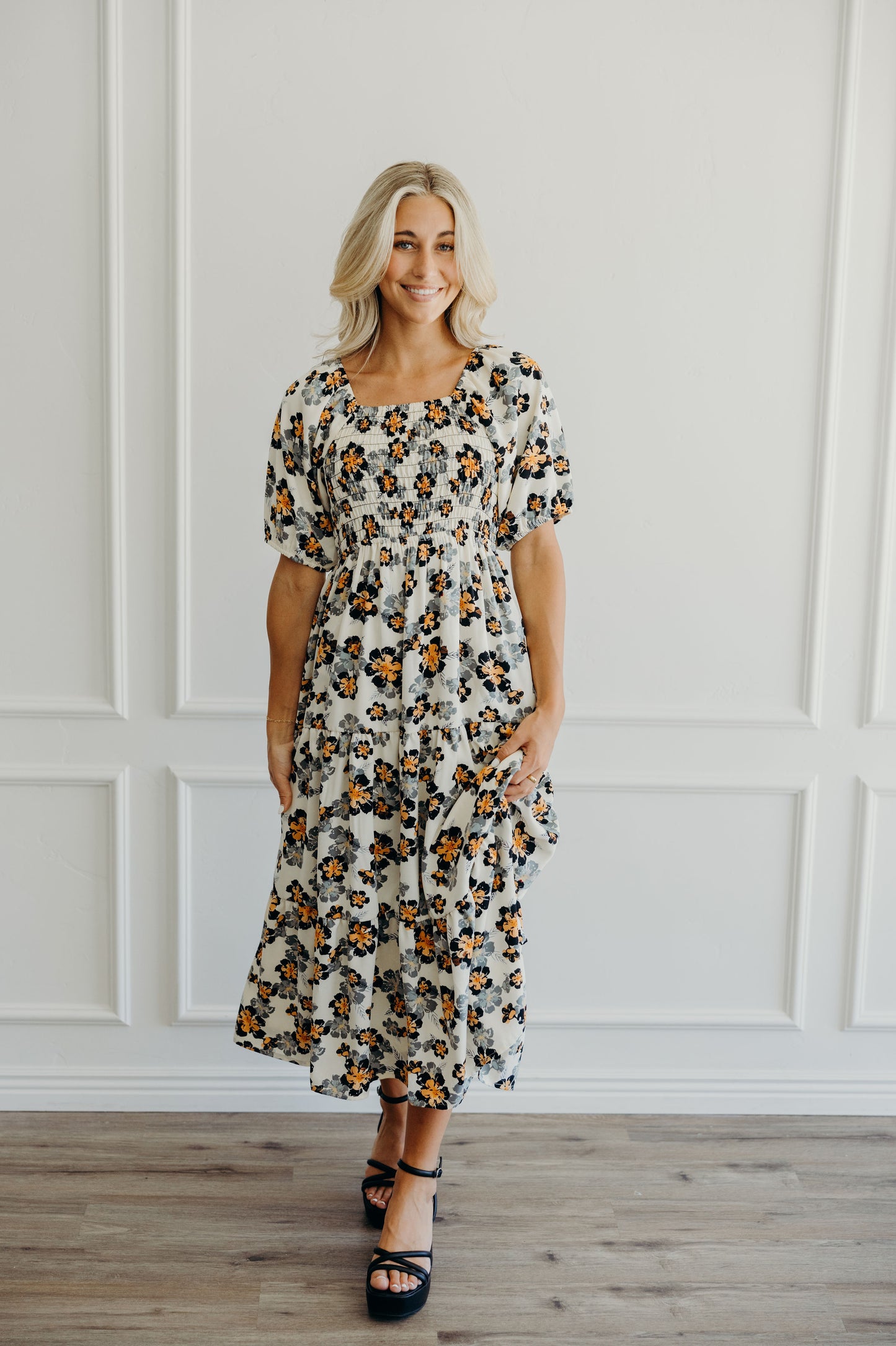 Midi length tiered dress with floral print, natural waistline, square neckline and puff sleeves.