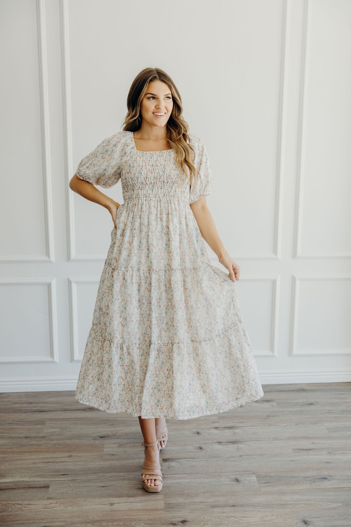 Fit and flair dress with pink and green floral print, smocked bodice, square neckline, and half sleeves.