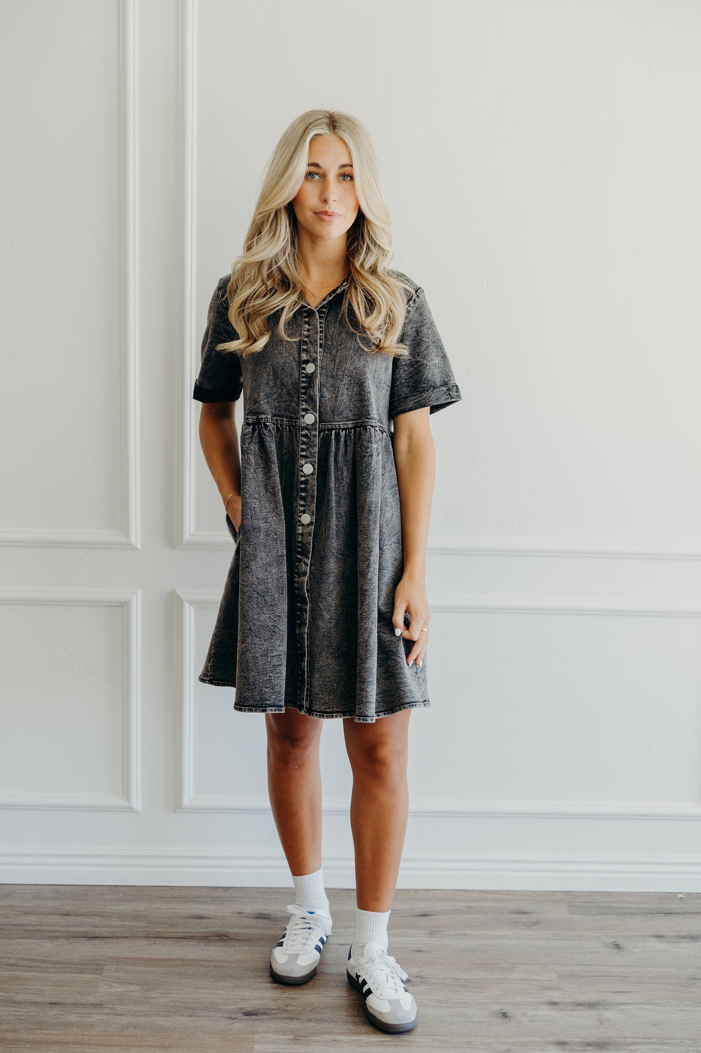 Knee length blak wash denim dress with pockets, short sleeves, and v neckline.