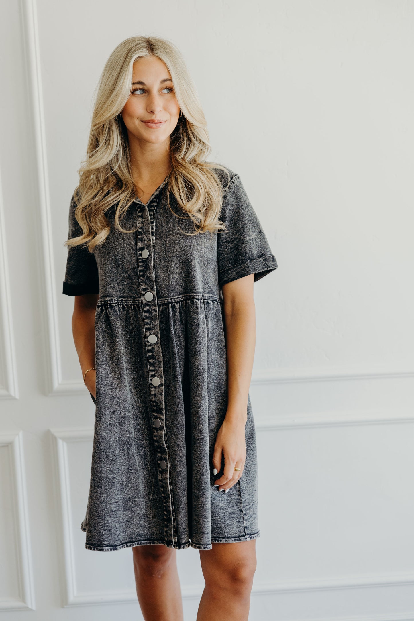 Fit and flare black denim was dress with metal buttons, collar, short cuffed sleeves and pockets.