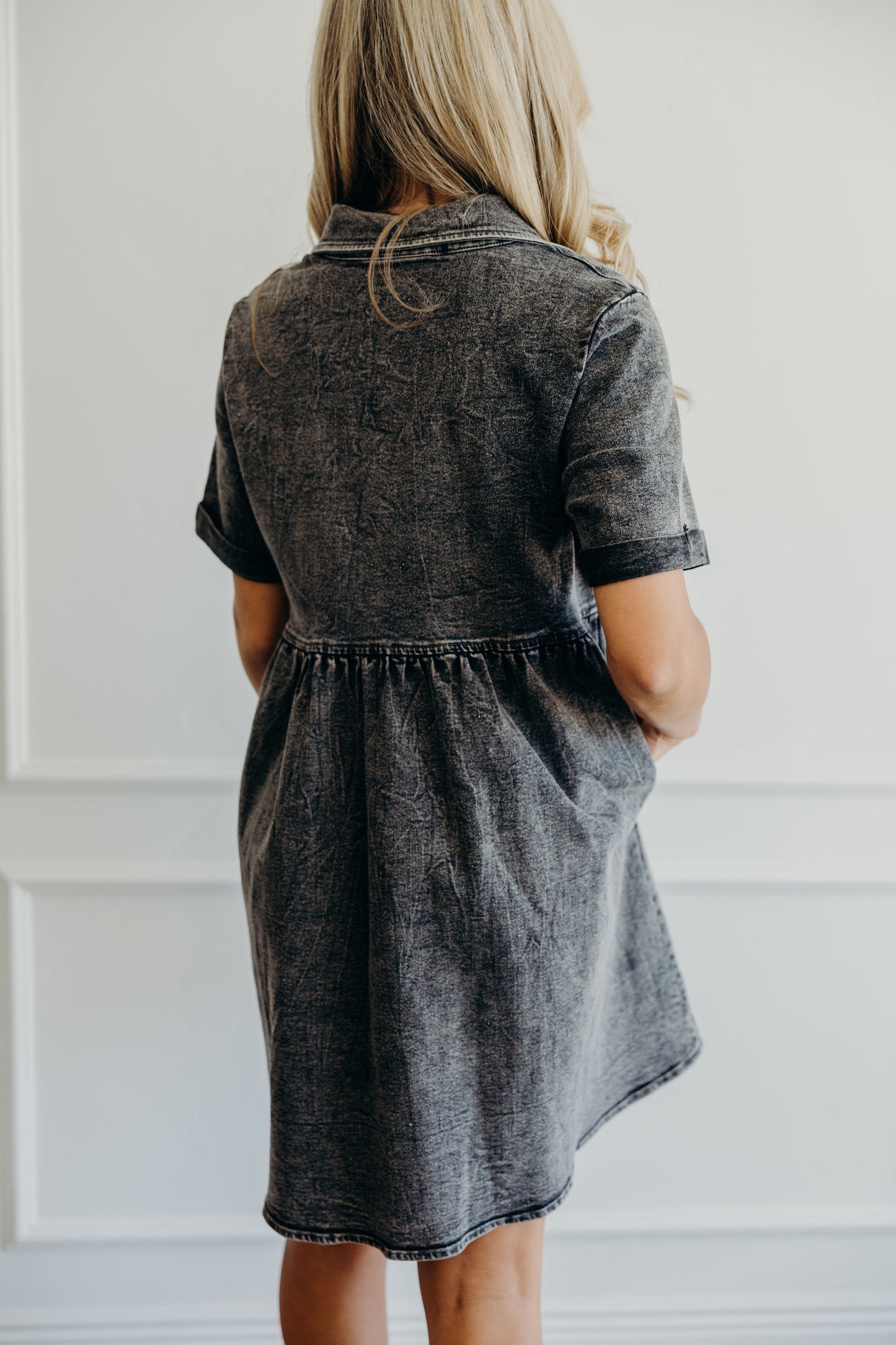 Detail shot of fit and flare silhouette of black wash denim dress.