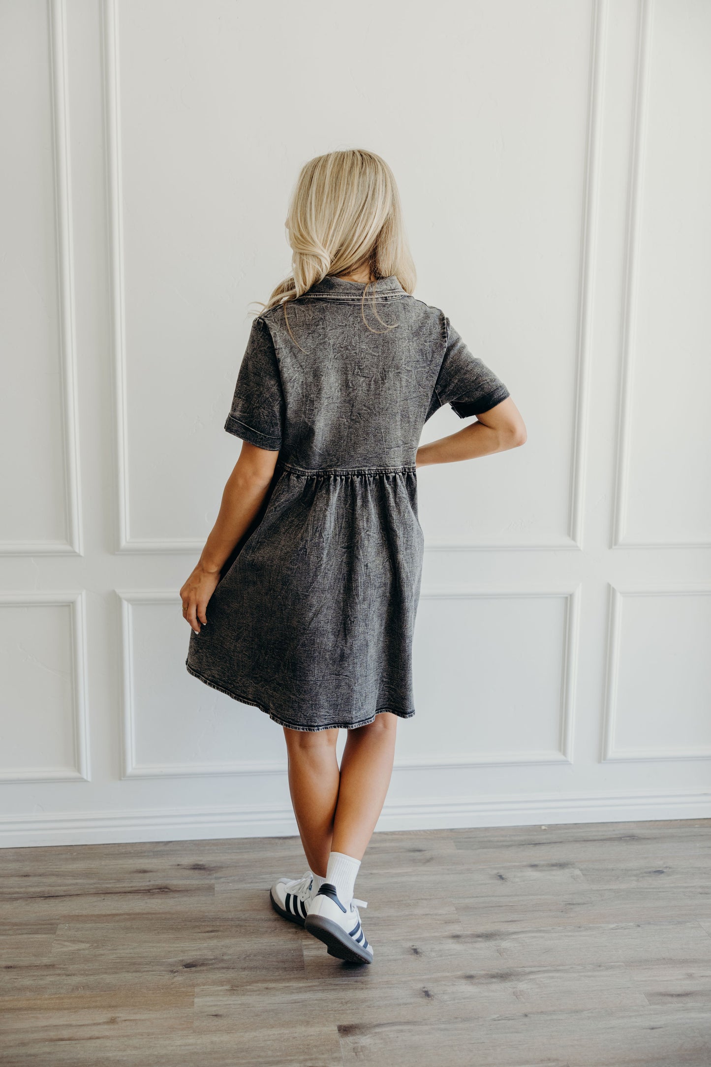 Back view of denim fit and flare dress with short sleeves and collar.