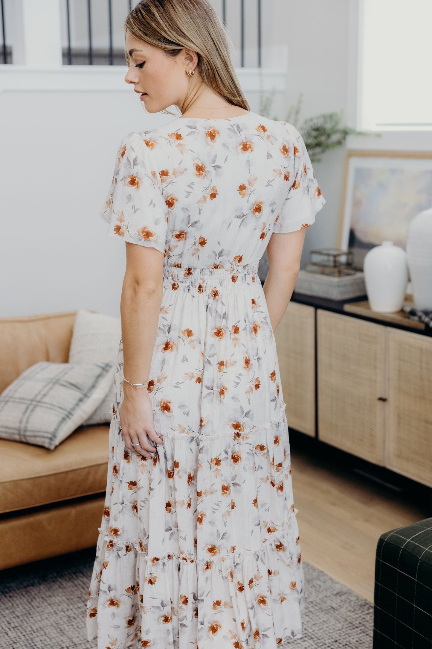 Back view of floral print dress with smocked waist and tiered skirt.