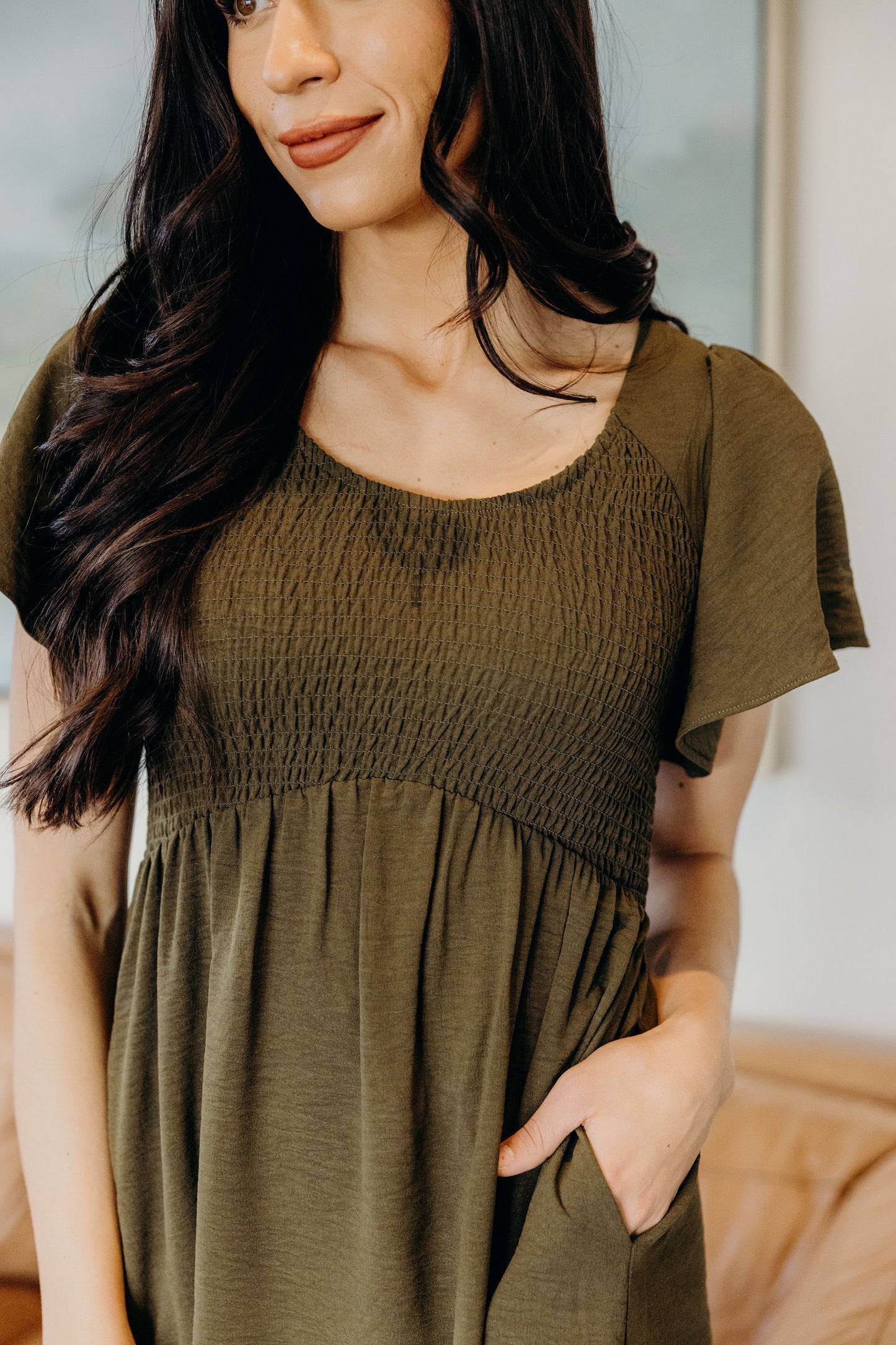 Olive green dress with smocked bodice and pockets.