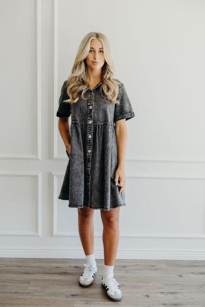 Knee length blak wash denim dress with pockets, short sleeves, and v neckline.