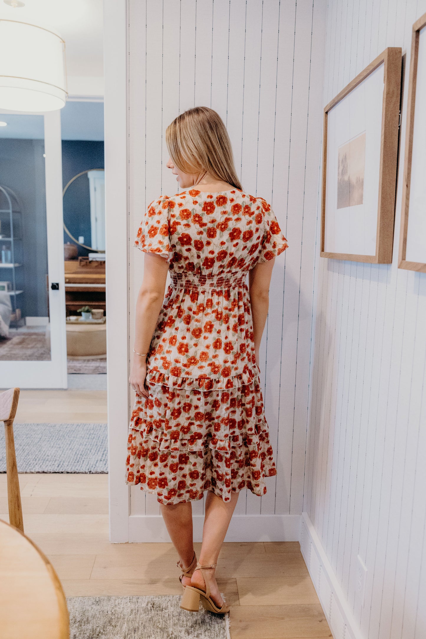 Back view of red print dress with fit and flare silhouette, tiered skirt, and flutter sleeves.