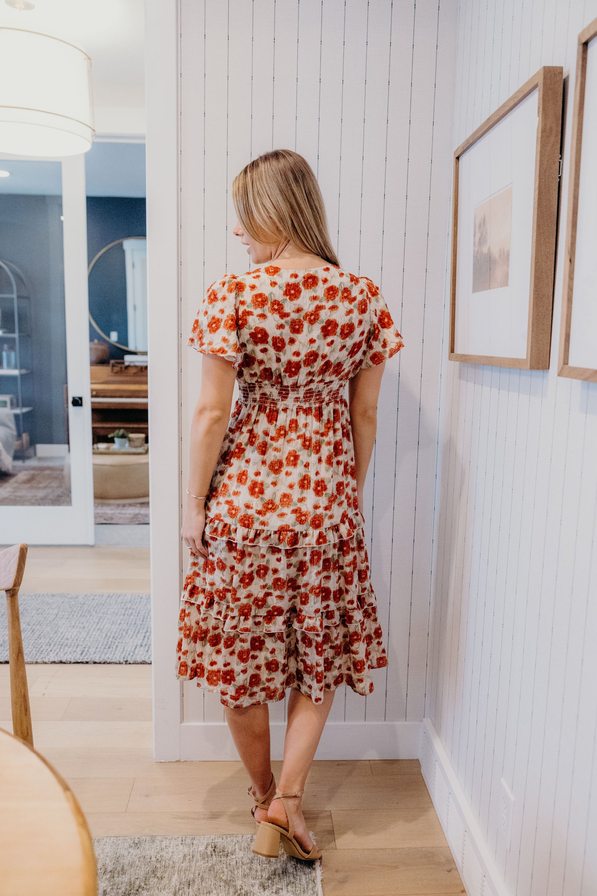 Back view of red print dress with fit and flare silhouette, tiered skirt, and flutter sleeves.